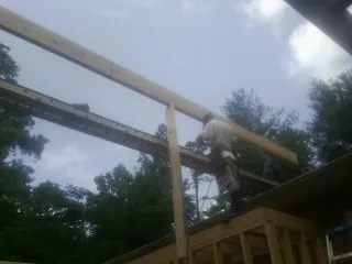 Carpenter setting a ridge beam over a new addition frame — Ice Dam Removal by Roofing Brothers in Nixa